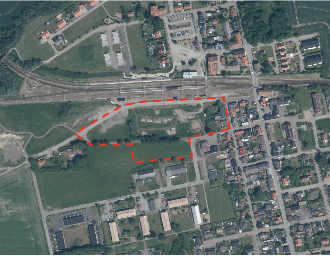 Flygfoto över Teckomatorp där planområdet intill järnvägsstationen är markerat med röd streckad linje.